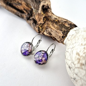 Paarse epoxy oorbellen hangend in het oor