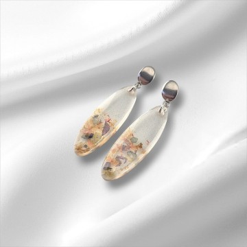 Bloemenregen oorbellen – ovale epoxy hanger met subtiele bladfragmenten