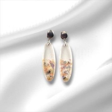 Close‑up van handgemaakte epoxy oorbellen met gedroogde bloemen en rvs pin